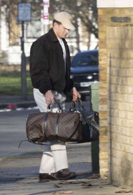 Adam Peaty carries two Louis Vuitton duffle bags while returning to Gordon Ramsay's house.