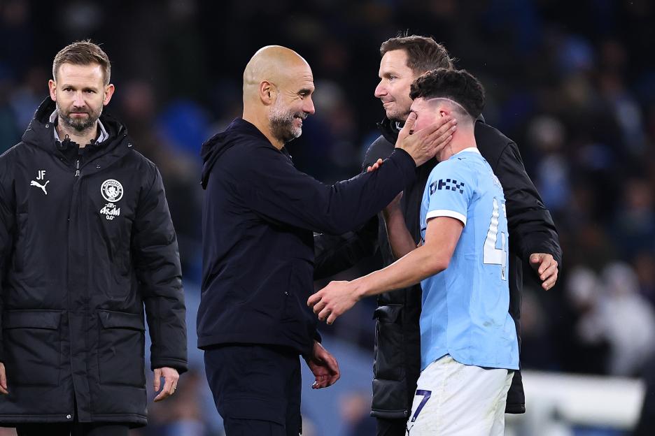 Manchester City manager Pep Guardiola embracing a player.