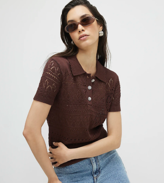 A woman wears a brown eyelet knit polo shirt and sunglasses.