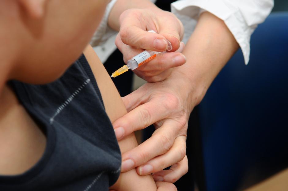 A doctor giving a vaccination to a young child.