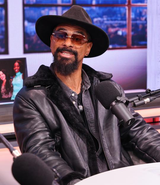 Former boxer and reality TV star David Haye wearing sunglasses and a hat, speaking into a microphone.