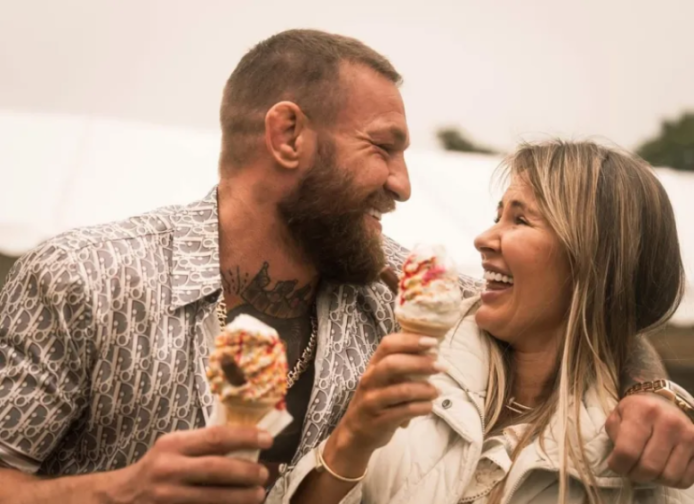 Conor McGregor and a woman laughing while holding ice cream cones.