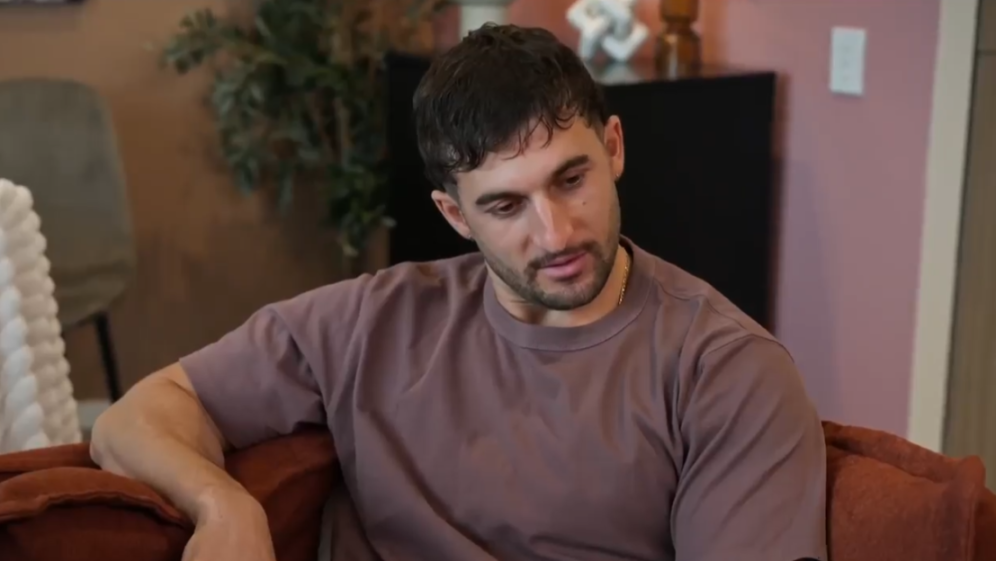Luke from MAFS Australia sitting on an orange couch.