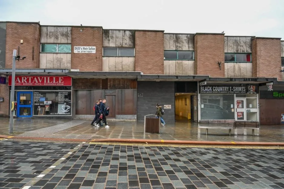 A row of rundown and shuttered shops on a town street in Dudley.