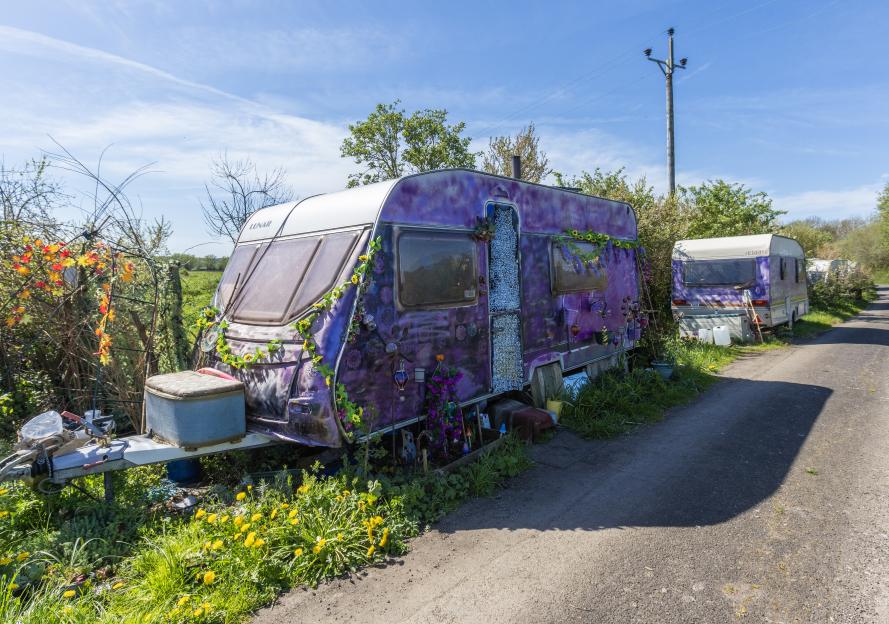 Caravans, some decorated with flowers, parked on Kennard Moor Drove in Glastonbury.