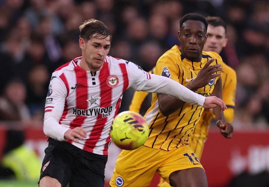 Two Premier League players, one in red and white stripes and another in yellow, compete for the ball.