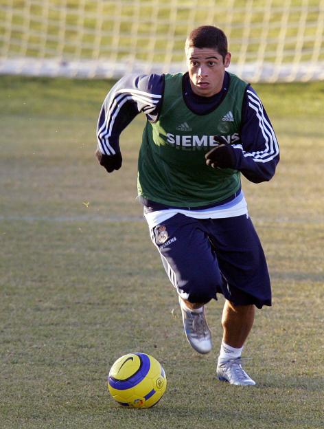 Cicinho from Real Madrid running with a soccer ball during a training session.