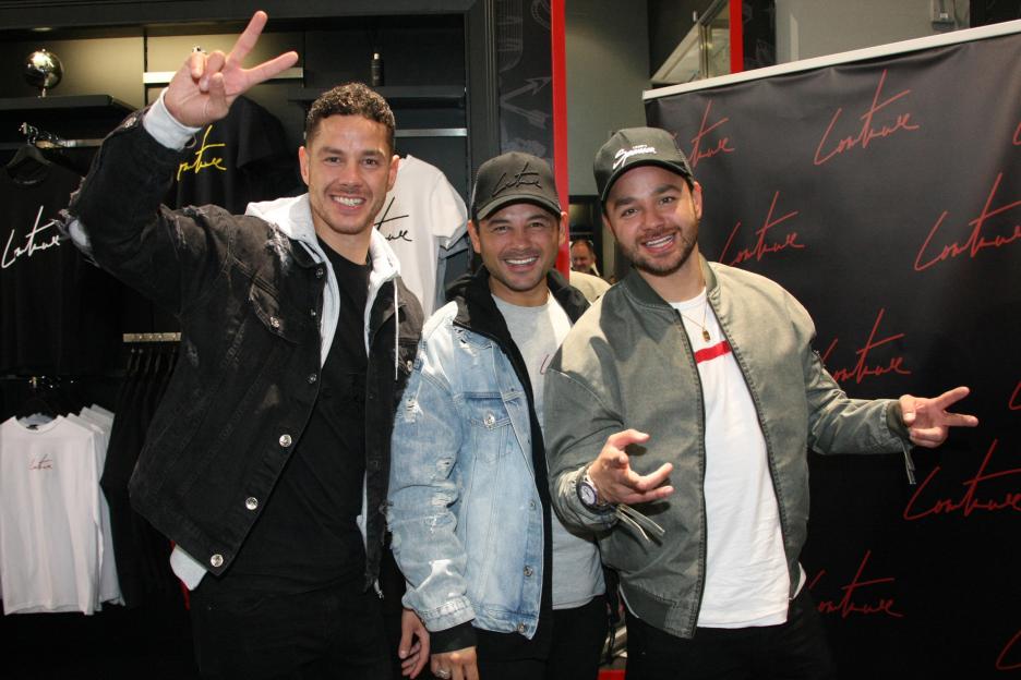 Ryan Thomas and his brothers Adam and Scott posing in a clothing store.