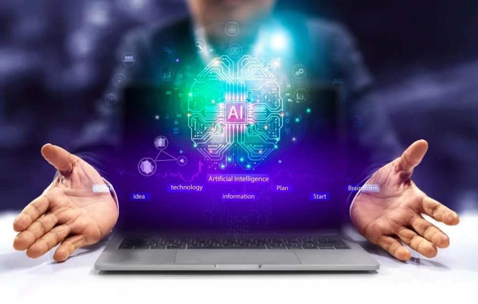 A person gesturing over a laptop with a glowing digital brain graphic representing artificial intelligence.