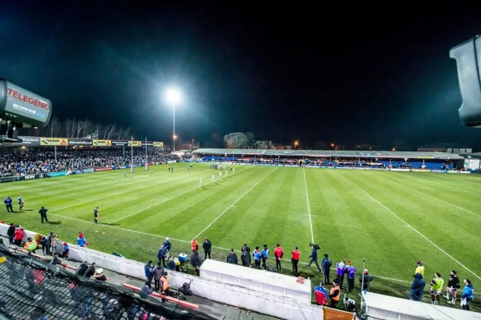 Rugby match at Wakefield's stadium under floodlights at night.