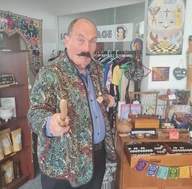 John Starkey, a TV psychic, in a shop surrounded by spiritual items.