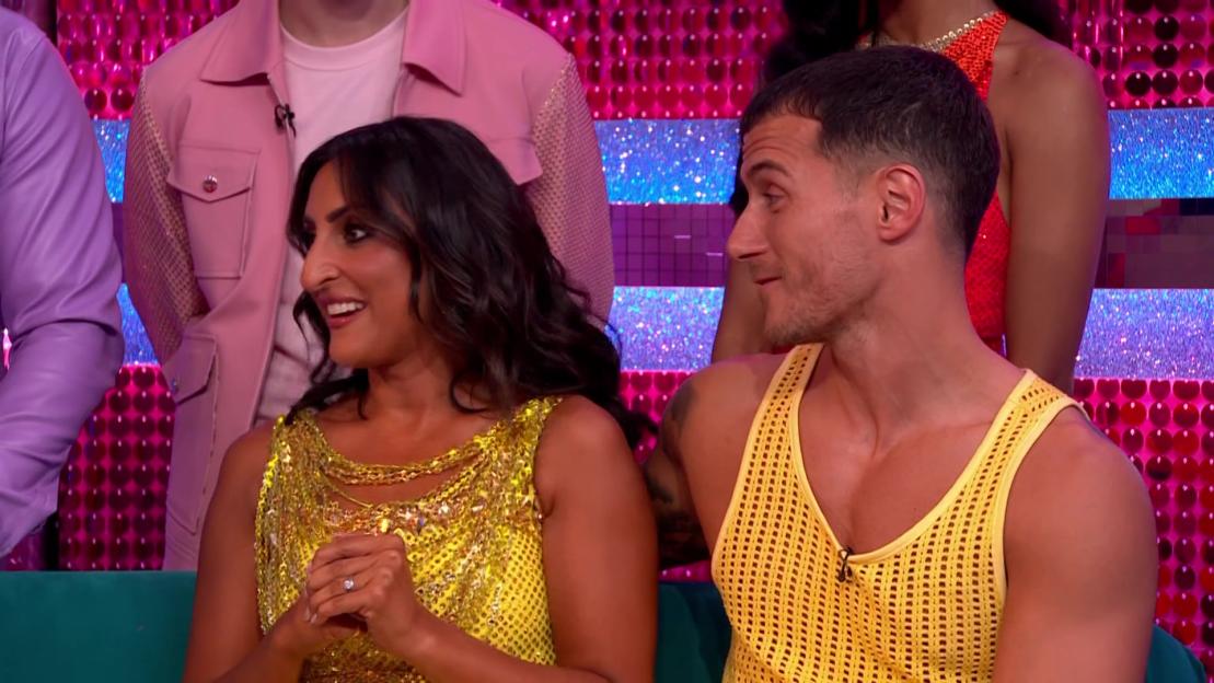 a man in a yellow tank top sits next to a woman in a yellow dress