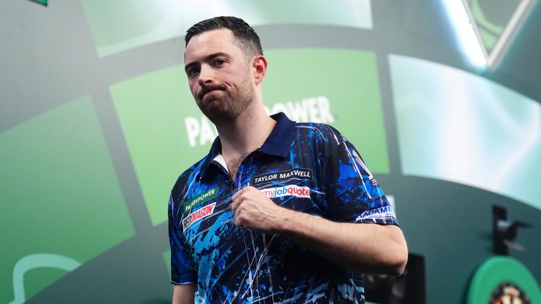 Luke Humphries, wearing a blue and white patterned shirt, celebrating during his match at the Paddy Power World Darts Championship.