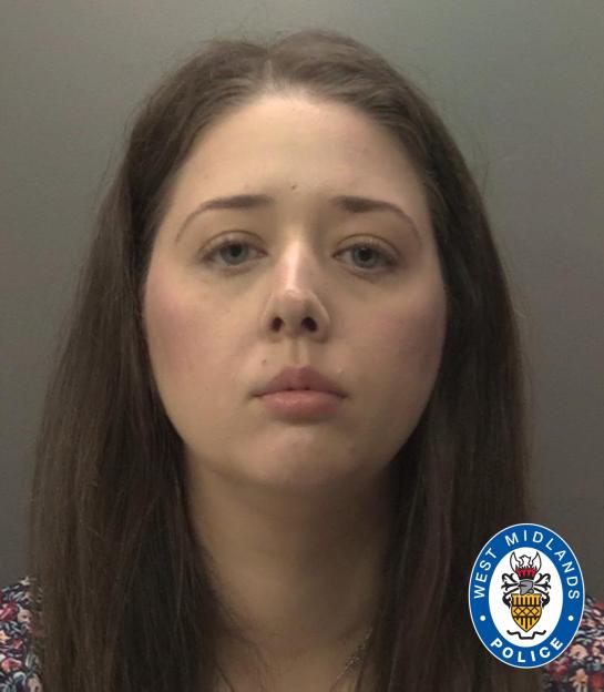 A mugshot of a young woman with long, brown hair and a serious expression.