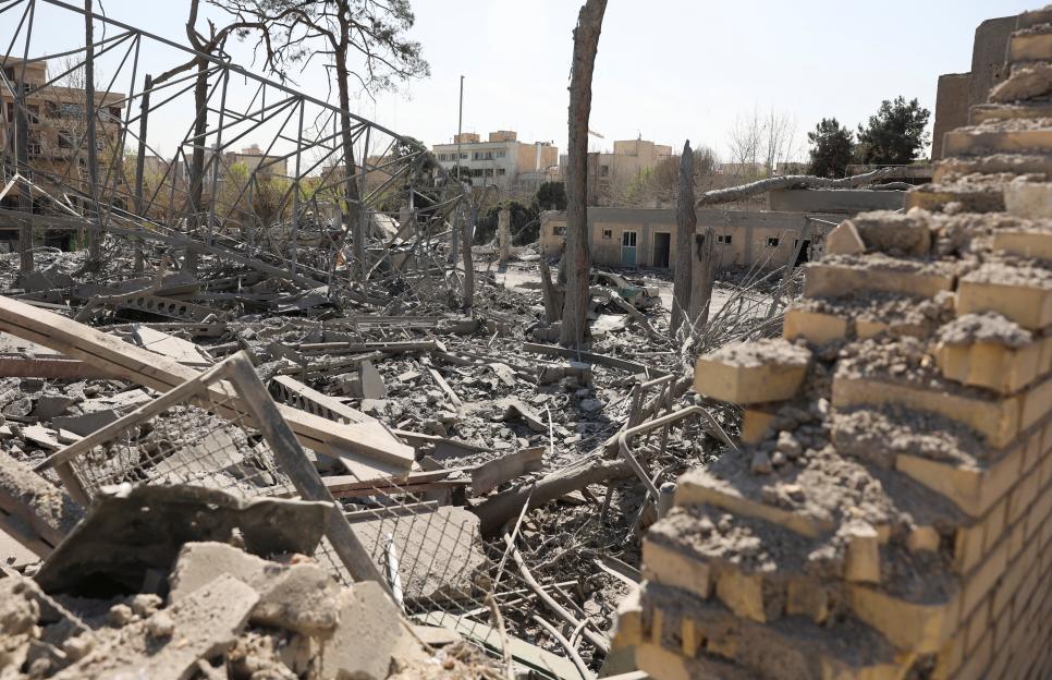 A destroyed police car sits amid rubble and debris at a police station in Tehran, Iran, following a strike.