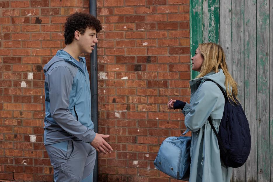 Megan and Will Driscoll talking, with Megan holding a bag.
