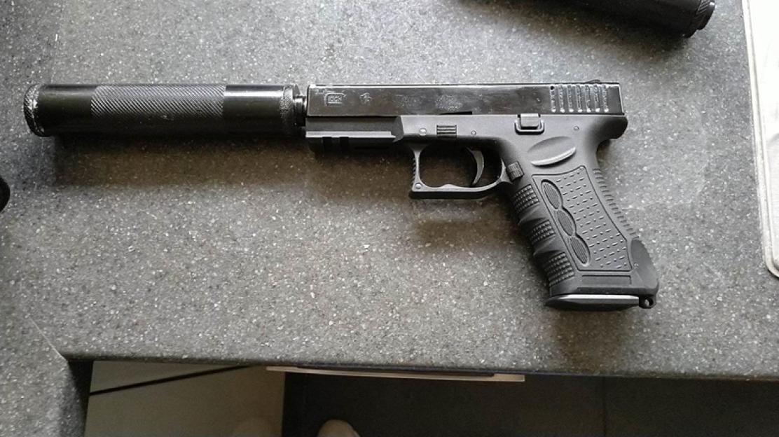 A handgun with a silencer attached to the barrel.