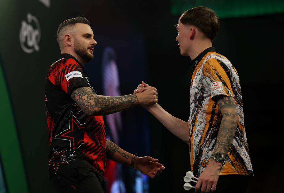 Joe Cullen and Bradley Brooks shake hands after a darts match.