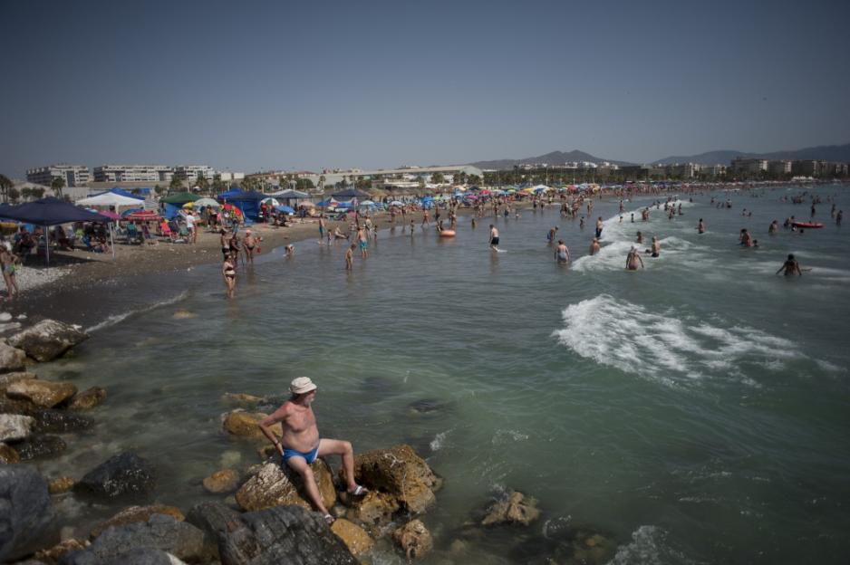 People on a crowded beach in Spain during a heatwave.