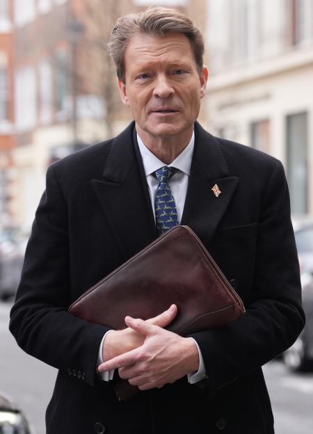 Richard Tice, deputy leader of Reform UK, holding a brown leather portfolio.