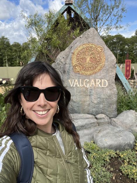 A woman smiling in front of a Valgard sign.