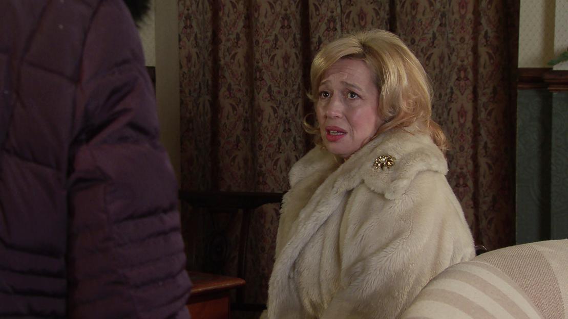 Julie Carl, wearing a fur coat, looking distraught while talking to Eileen Grimshaw.
