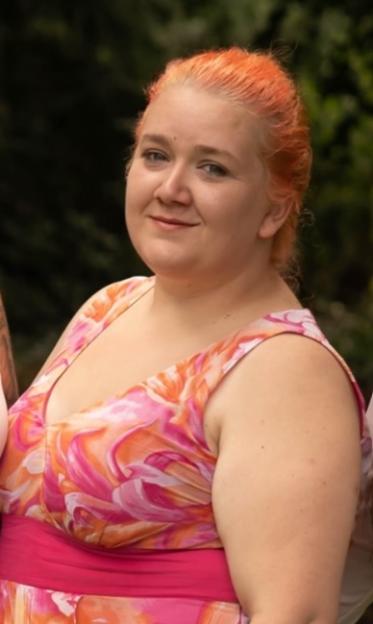 Rhiannon Skye Whyte, a woman with orange hair and a floral dress.