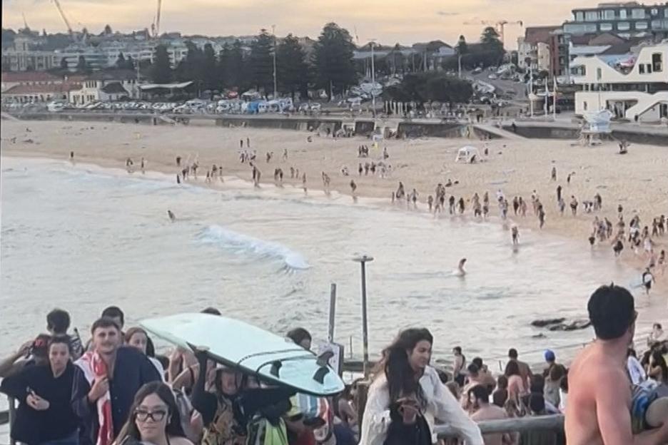 Beachgoers fleeing Bondi Beach after gunfire.