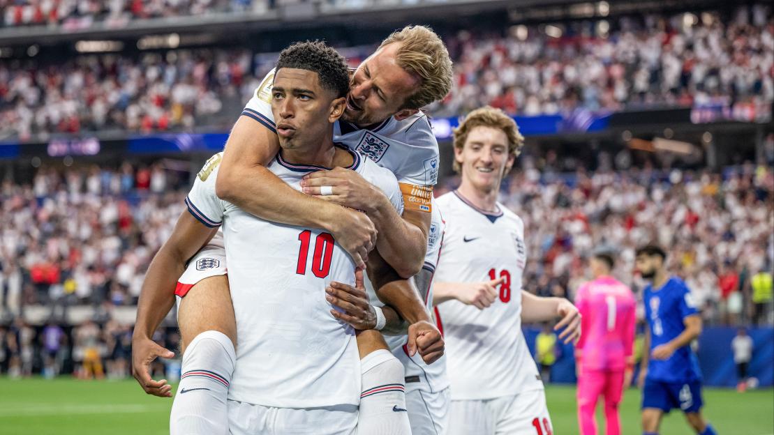 Jude Bellingham celebrating his team's third goal with Harry Kane and Anthony Gordon.