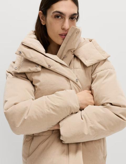 Woman modeling a beige peached Thermowarmth™ padded puffer jacket.