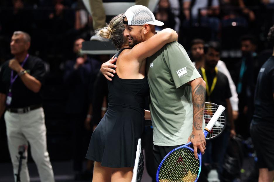Aryna Sabalenka and Nick Kyrgios embrace at the net after a tennis match.