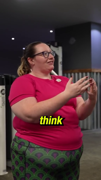 A plus-size personal trainer speaking and gesturing with her hands.