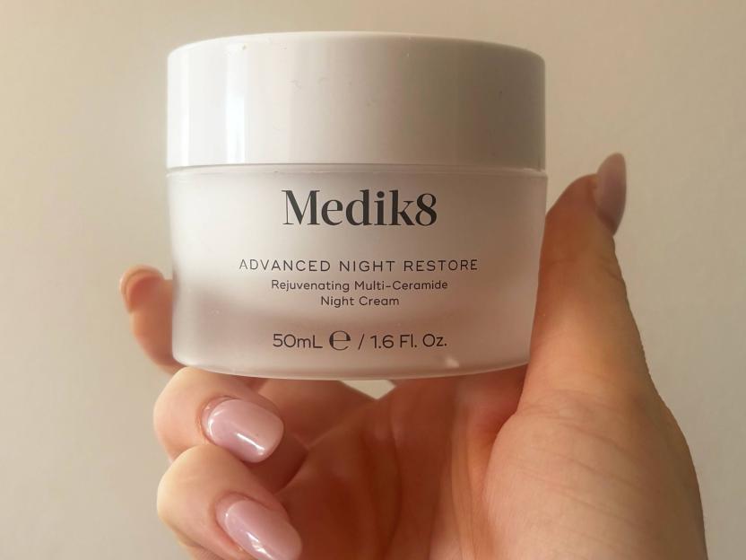 Hand holding a jar of Medik8 Advanced Night Restore Rejuvenating Multi-Ceramide Night Cream.