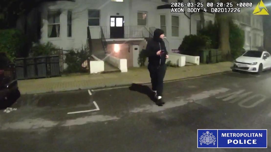 A screen grab from a police bodycam showing Anthony Durkan walking down a residential street at night.