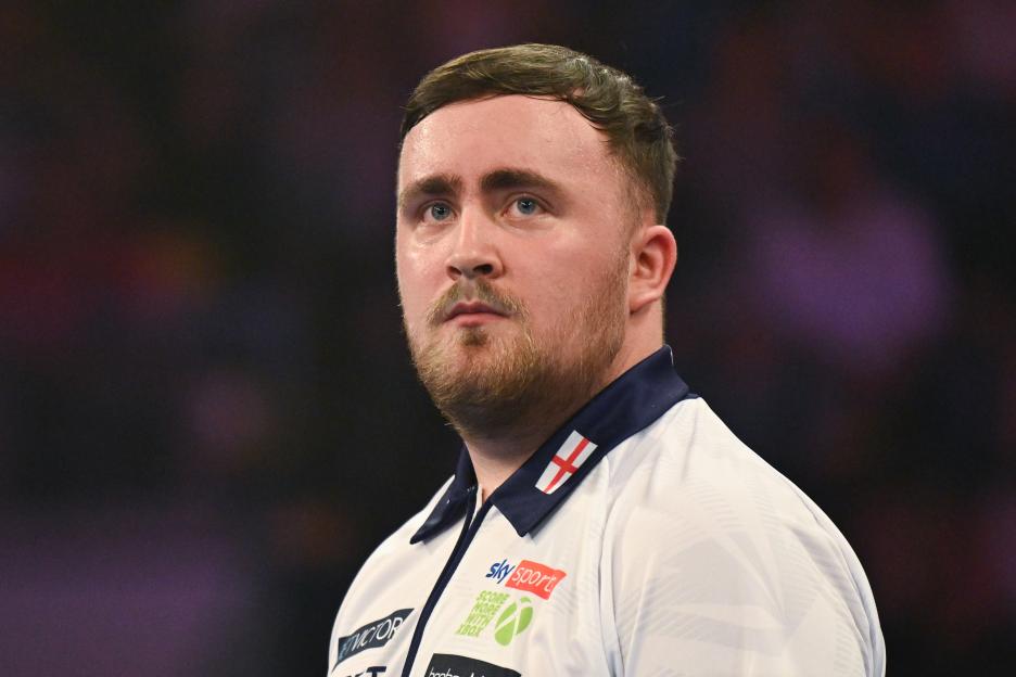 Luke Littler of England looking on during a darts match.