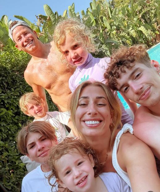Joe Swash, Stacey Solomon, and five children pose for a family selfie.