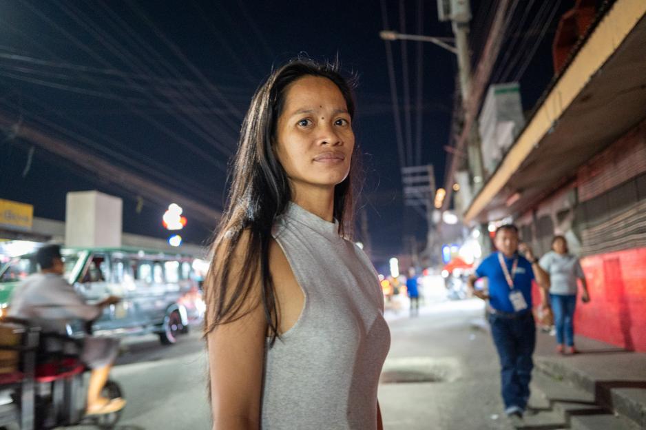 Abigail Ocampo Jurado standing at night on Fields Avenue where she sells roses.