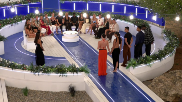 Contestants of a reality TV show gather on a circular stage.