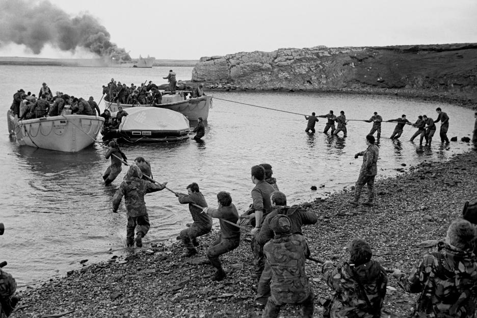 Survivors from a smoking ship being pulled ashore by colleagues during the Falklands War.