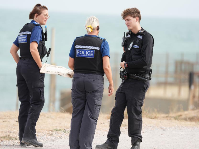 Three police community support officers near water.