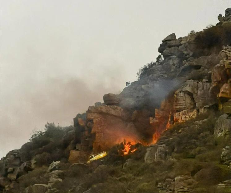 The Working on Fire Bell Huey helicopter crashed into the very fire it was trying to extinguish when its rotors hit the cliff as it hovered above it and began to release 1000 litres of water on it to try and douse it. Without its rotors the helicopte