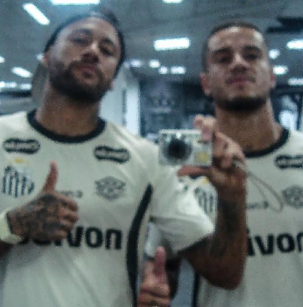 Neymar and another man taking a selfie in matching jerseys.