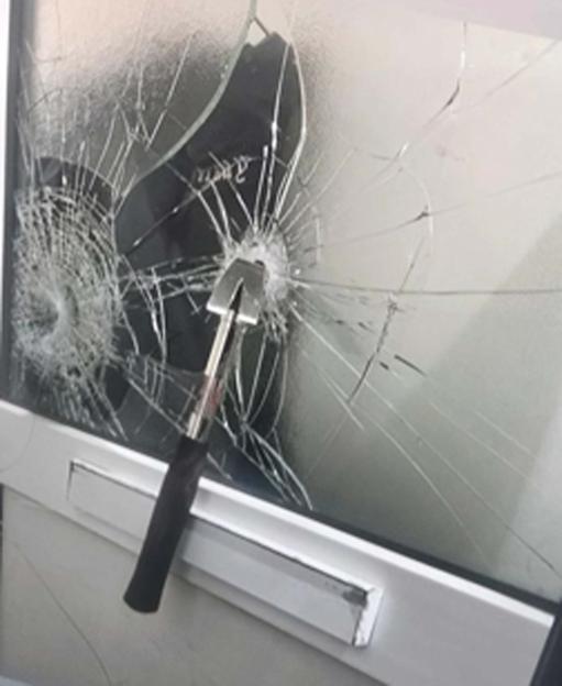 Hammer embedded in glass after attack