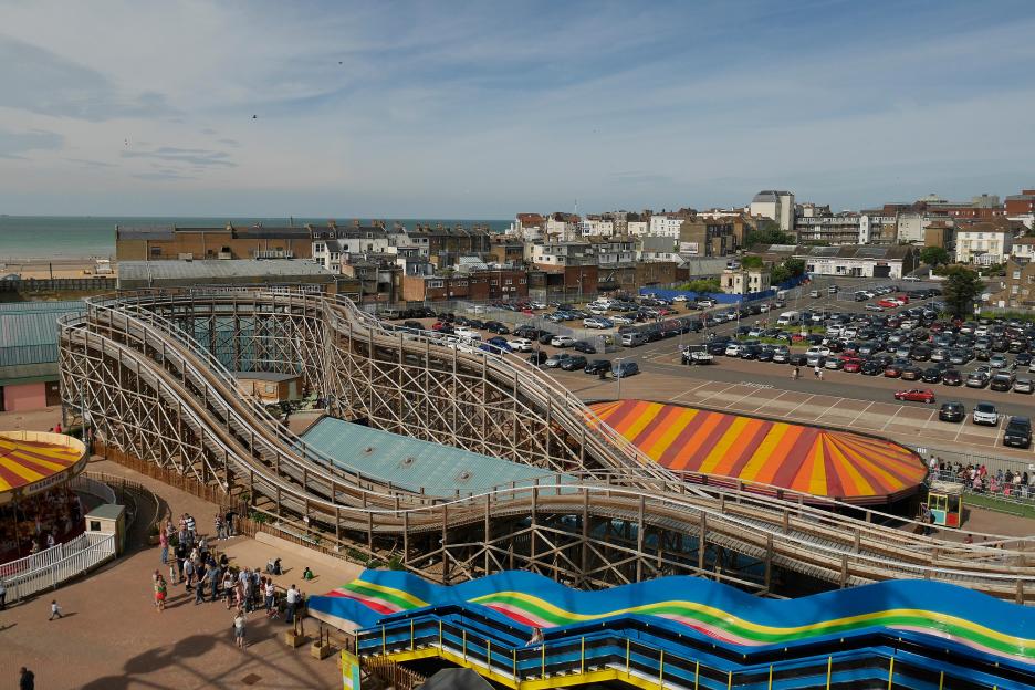 An elevated view of The Scenic Railway roller coaster at Dreamland Margate, with a large "ZEPPELIN" sign to the right and the ocean in the background, circa 1980s.