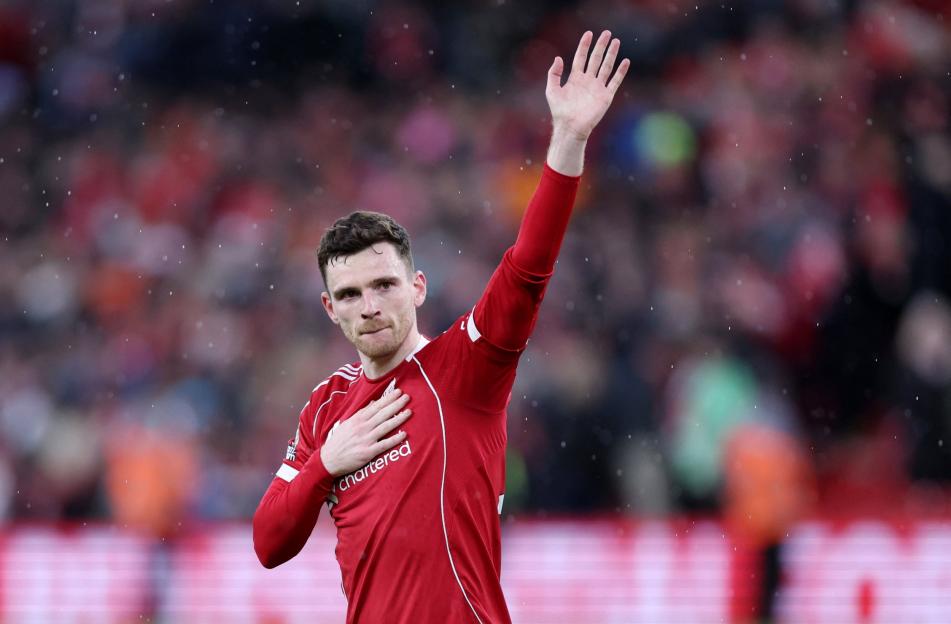 Liverpool player Andy Robertson waves to the crowd with his hand over his heart.