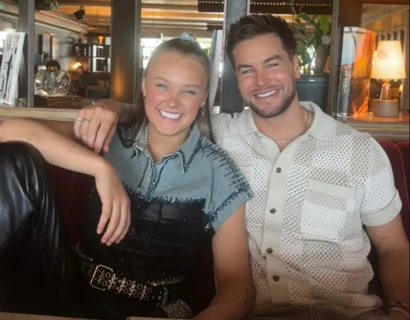 Jojo Siwa and Chris Hughes smiling.