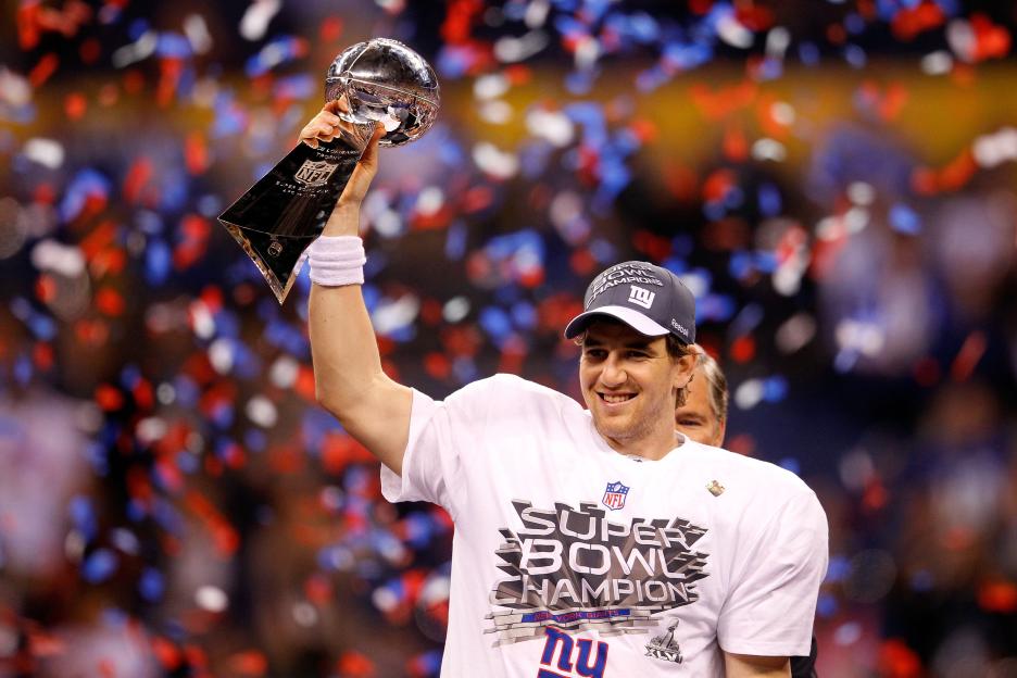 Eli Manning holding up the Vince Lombardi Trophy after Super Bowl XLVI.