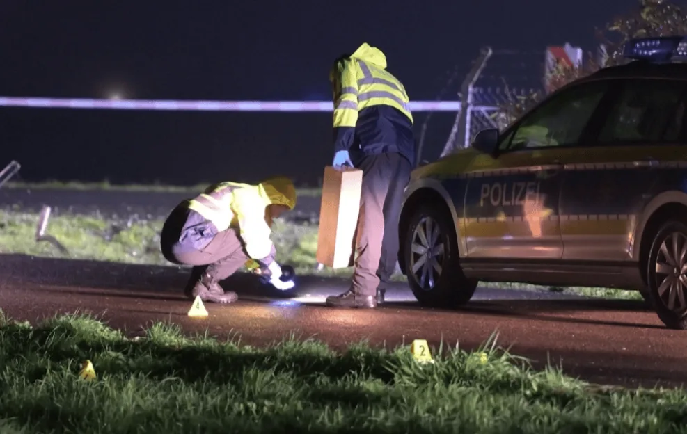Police officers investigate the scene at Leipzig Airport at night, following a security breach where a car drove onto the grounds.