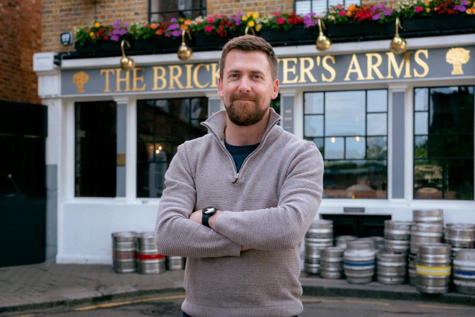 Man with a beard standing in front of The Bricklayers Arms pub.