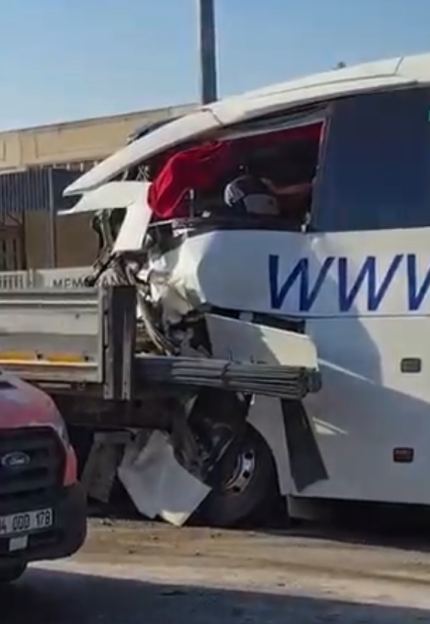 A white bus with a "WWW" logo that crashed into the back of a truck, causing extensive damage to the front right side of the bus.